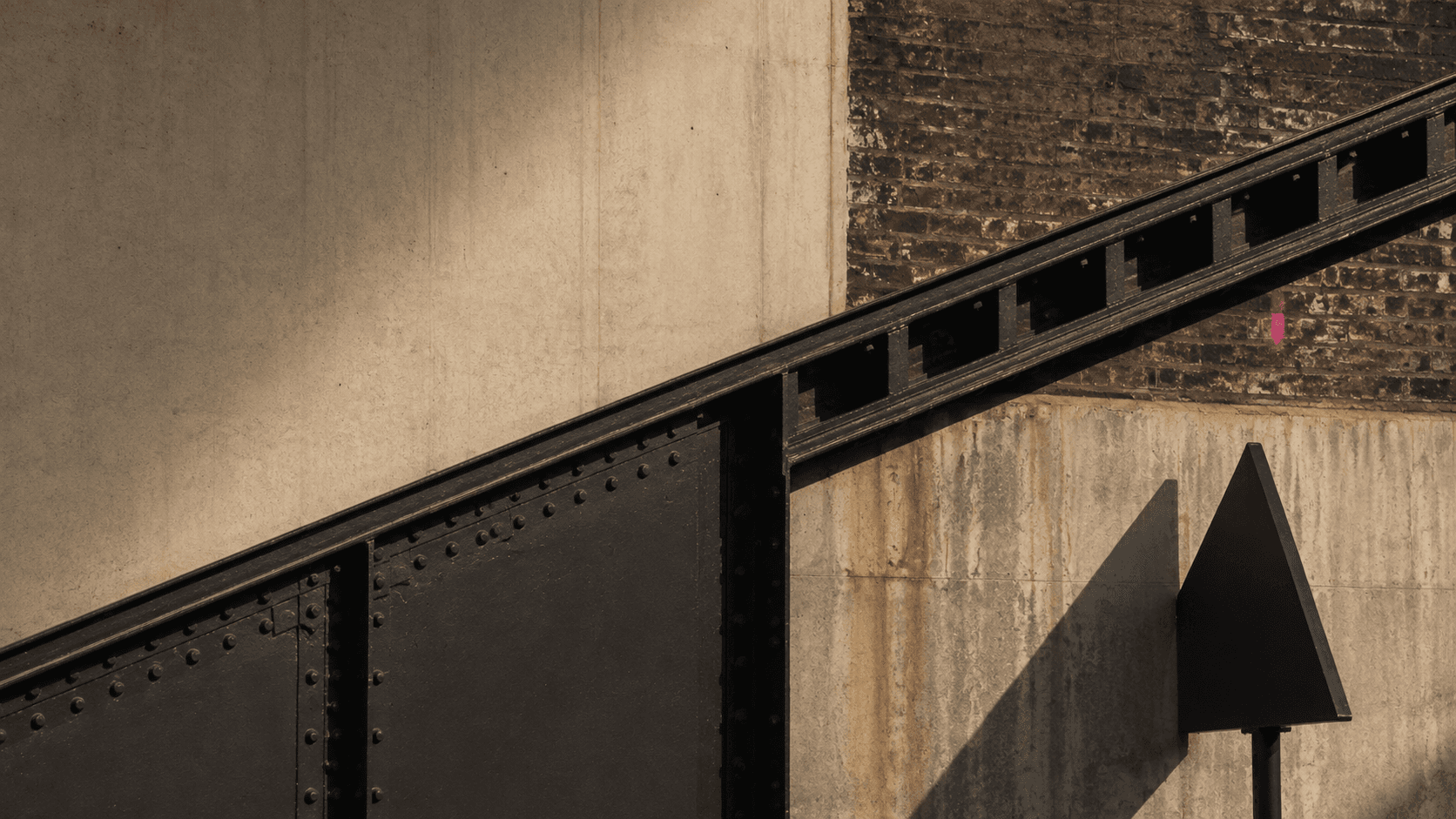 Concrete, brick, and black structural steel crossed by hard light