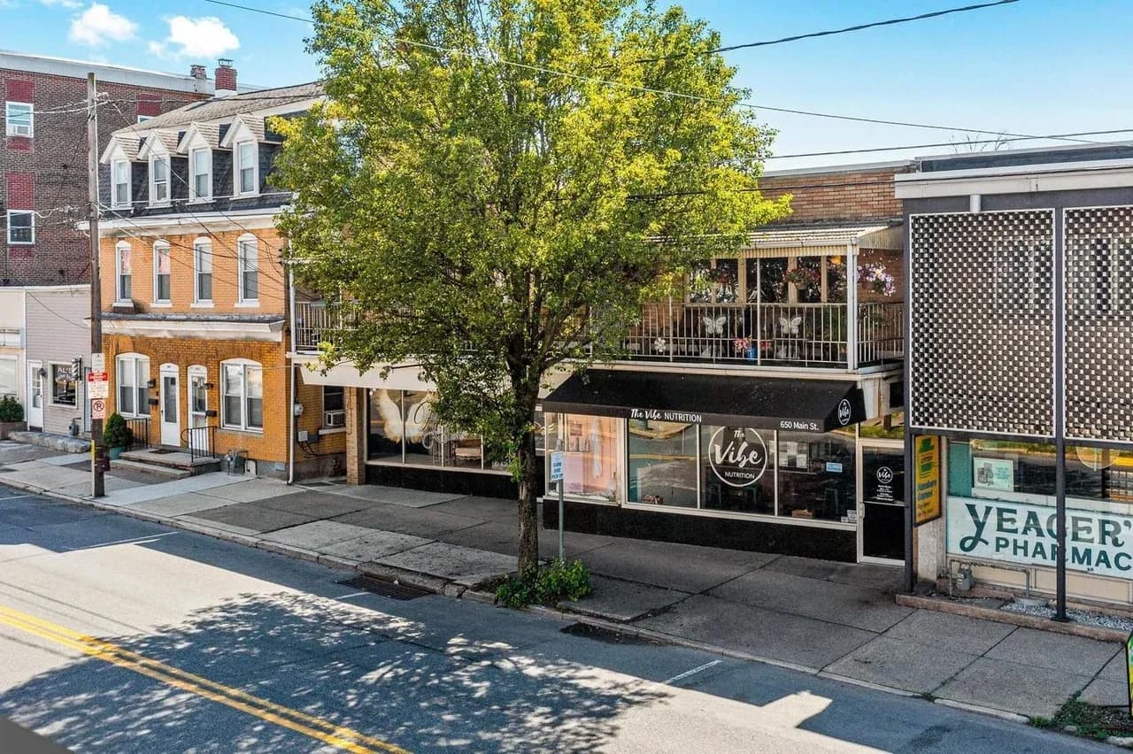 A Hellertown streetscape with storefronts, sidewalk, and a street tree